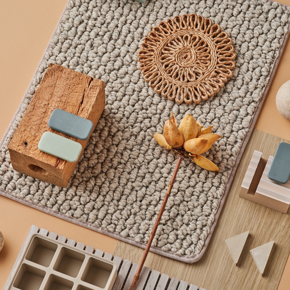 A wool rug styled with paint-chip colour swatches and natural material samples