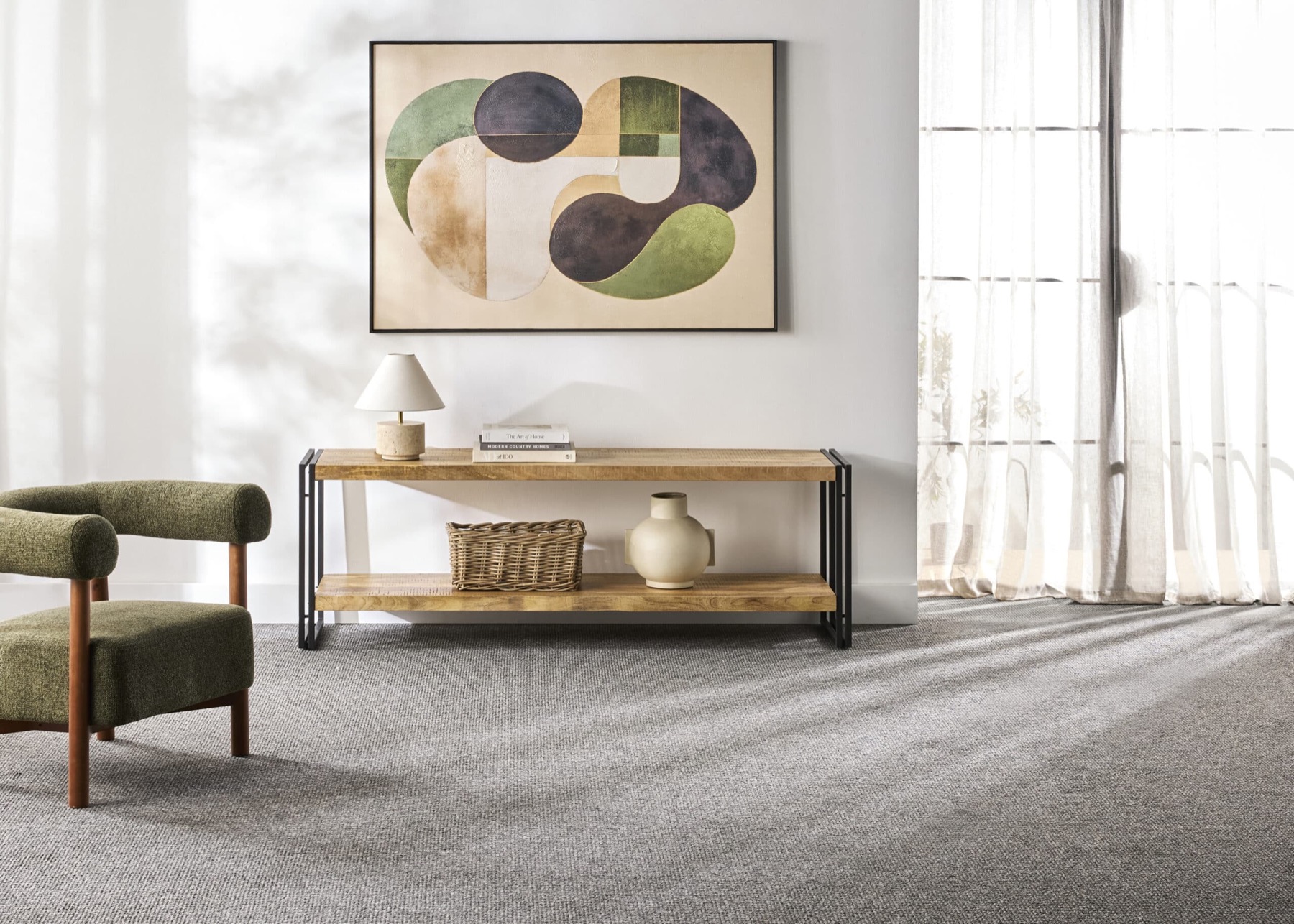A calm, styled living room with a soft rug laid over a timber floor